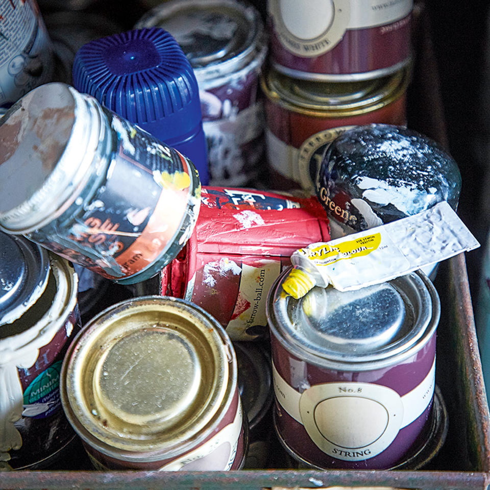 Box of opened and used paint cans