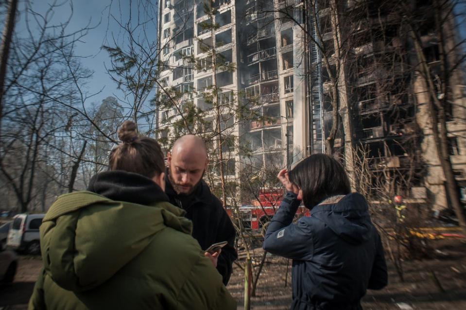 Residents of a building in Kyiv watch the fire extinguishing after an morning air attack (Alina Smutko)