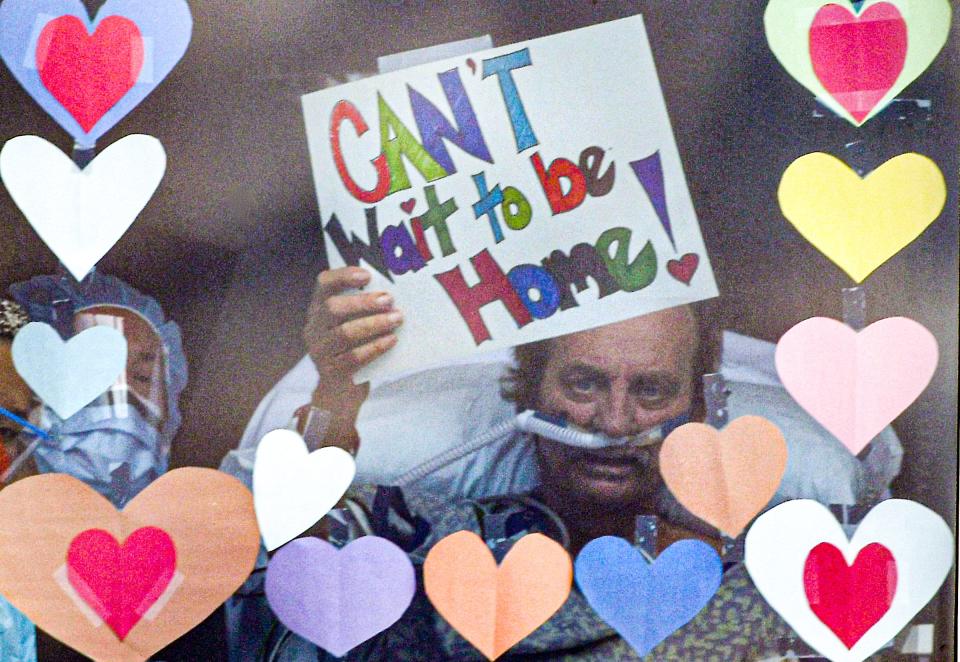 Richard Frady, a recovering COVID-19 patient in the intensive care unit at AnMed Health in Anderson, S.C., waves a "Can't Wait to be Home!" sign on his 32nd day after diagnosis to his wife, Sally, and daughter Allison Nissen from his window at the hospital April 28.