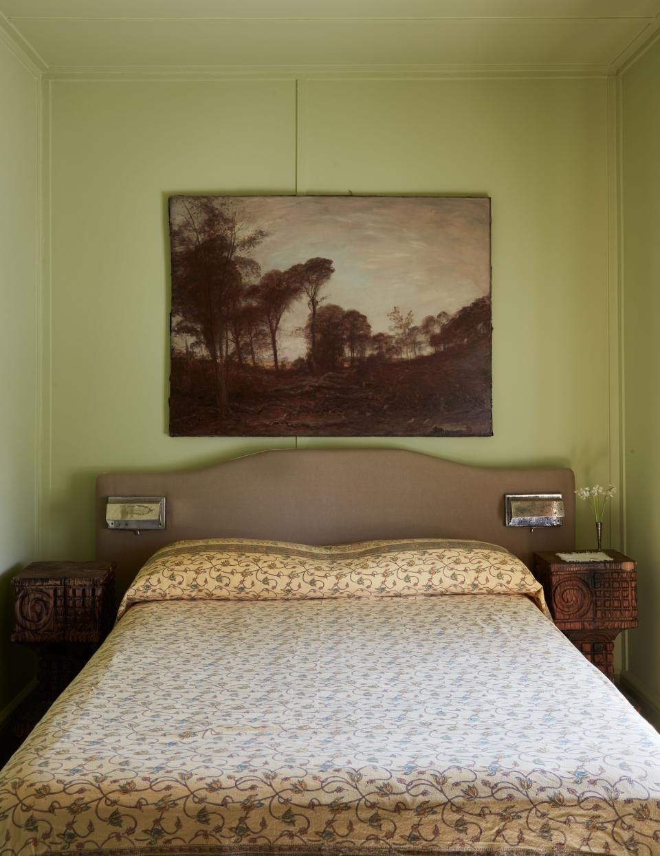 A custom-made headboard incorporates vintage fixtures as reading lights.