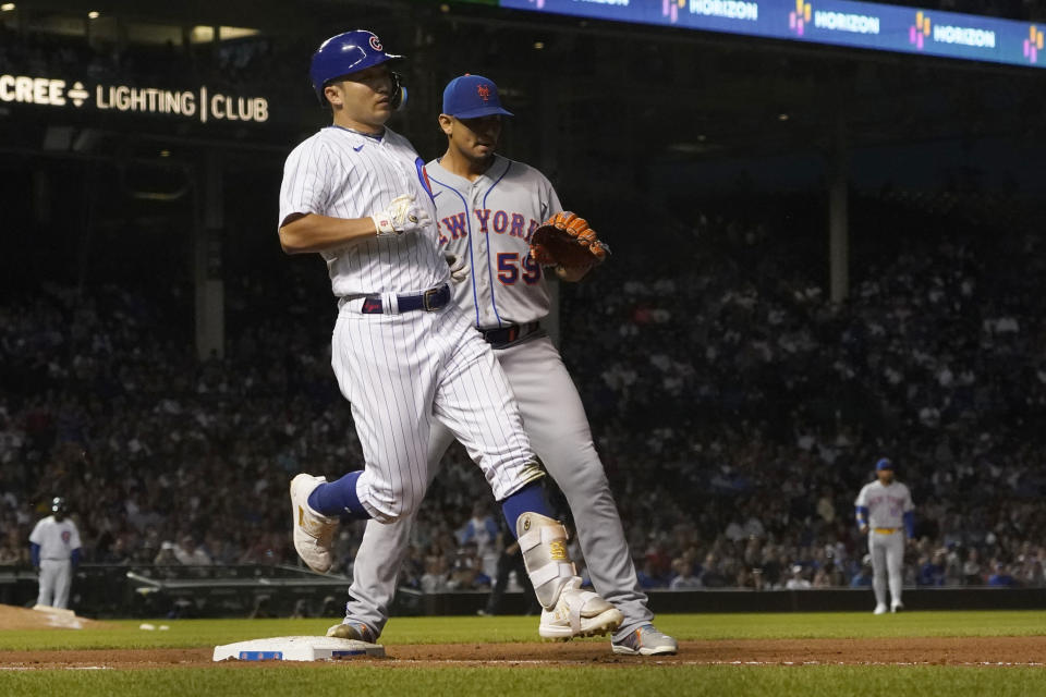 Chicago Cubs' Seiya Suzuki reaches first on a single off New York Mets starting pitcher Carlos Carrasco (59) during the sixth inning of a baseball game Thursday, July 14, 2022, in Chicago. (AP Photo/Charles Rex Arbogast)