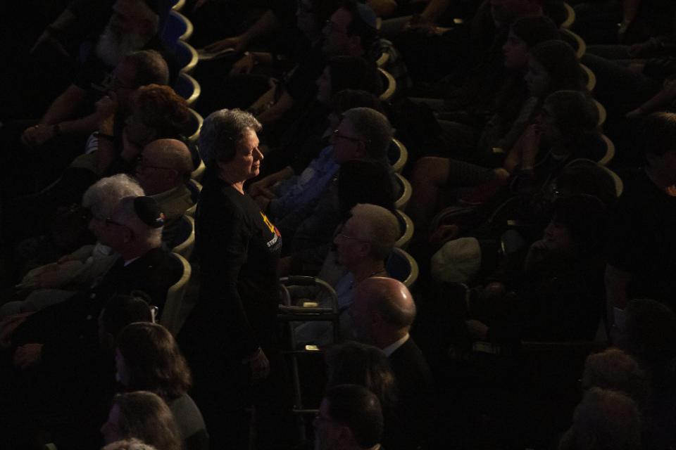 A family member of one of the victims returns to her seat after lighting candles on stage during the one-year commemoration of the Tree of Life synagogue attack at Soldiers & Sailors Memorial Hall and Museum, Sunday, Oct. 27, 2019, in Pittsburgh. A year ago, a gunman entered the Tree of Life synagogue and killed 11 members of three congregations, Dor Hadash, New Light and Tree of Life/Or L'Simcha, holding Shabbat services in the building. (AP Photo/Rebecca Droke)