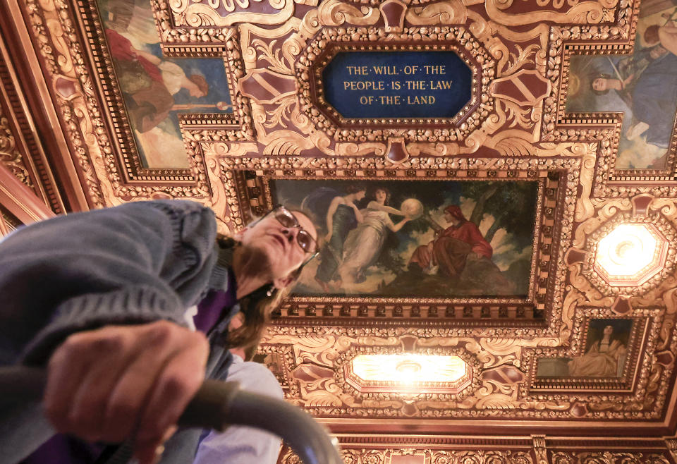Carlen Beshen, the former organizing director with the Fair Maps Coalition, walks beneath a painted quotation by former Wisconsin governor and U.S. senator Robert M. La Follette in the Governor's Conference Room at the Wisconsin State Capitol after Governor Tony Evers signed a bill which redraws the state's legislative maps in Madison, Wis. Monday, Feb. 19, 2024. Democrats tried unsuccessfully for more than a decade to overturn the Republican-drawn maps. But it wasn’t until control of the state Supreme Court flipped in August after the election of liberal Justice Janet Protasiewicz that Democrats found a winning formula. (John Hart/Wisconsin State Journal via AP)