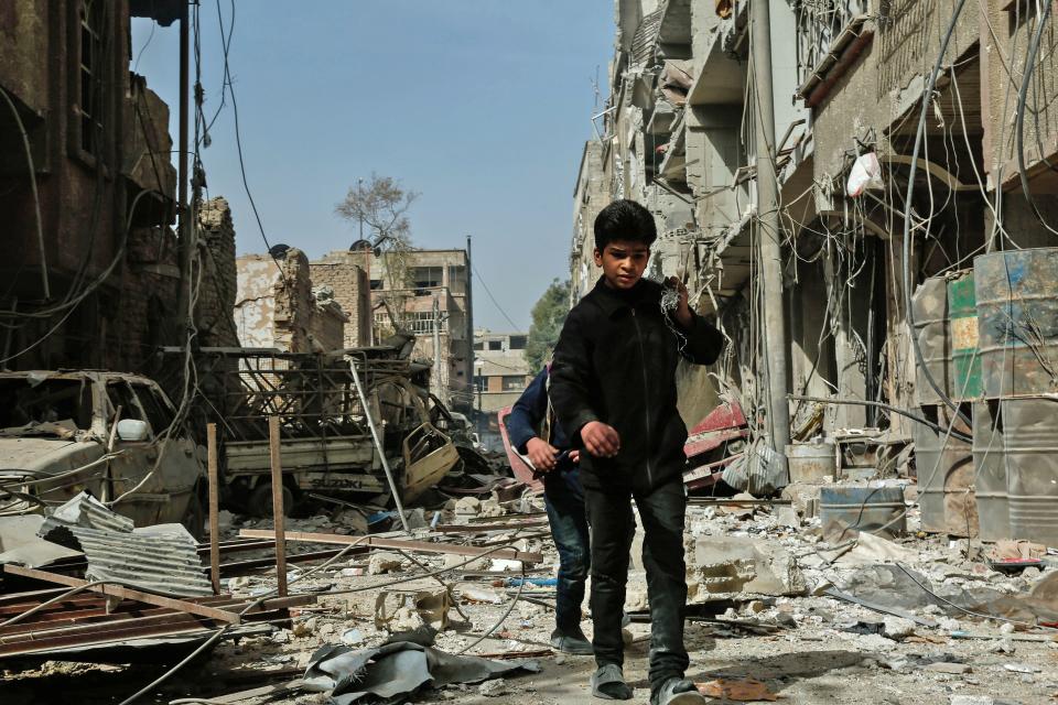 Children walk among the rubble after an airstrike in Douma, in the eastern Ghouta region of Syria, on Monday. The latest strikes killed at least 13 people overnight, the Syrian Observatory for Human Rights said.&nbsp; (Photo: HASAN MOHAMED/AFP via Getty Images)