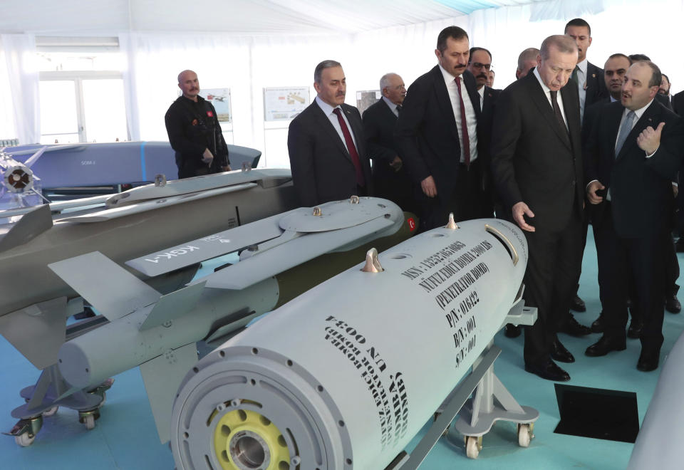 FILE - In this file photo dated Wednesday, Oct. 31, 2018, Turkey's President Recep Tayyip Erdogan, second right, listens to Technology Minister Mustafa Varank, right, at a defence technology development meeting, in Ankara, Turkey. Erdogan has been threatening a military offensive into northeastern Syria since at least September, aiming to prevent a “terror corridor” along Turkey’s southern border and wanting to create safe zones. (Presidential Press Service FILE via AP, Pool)