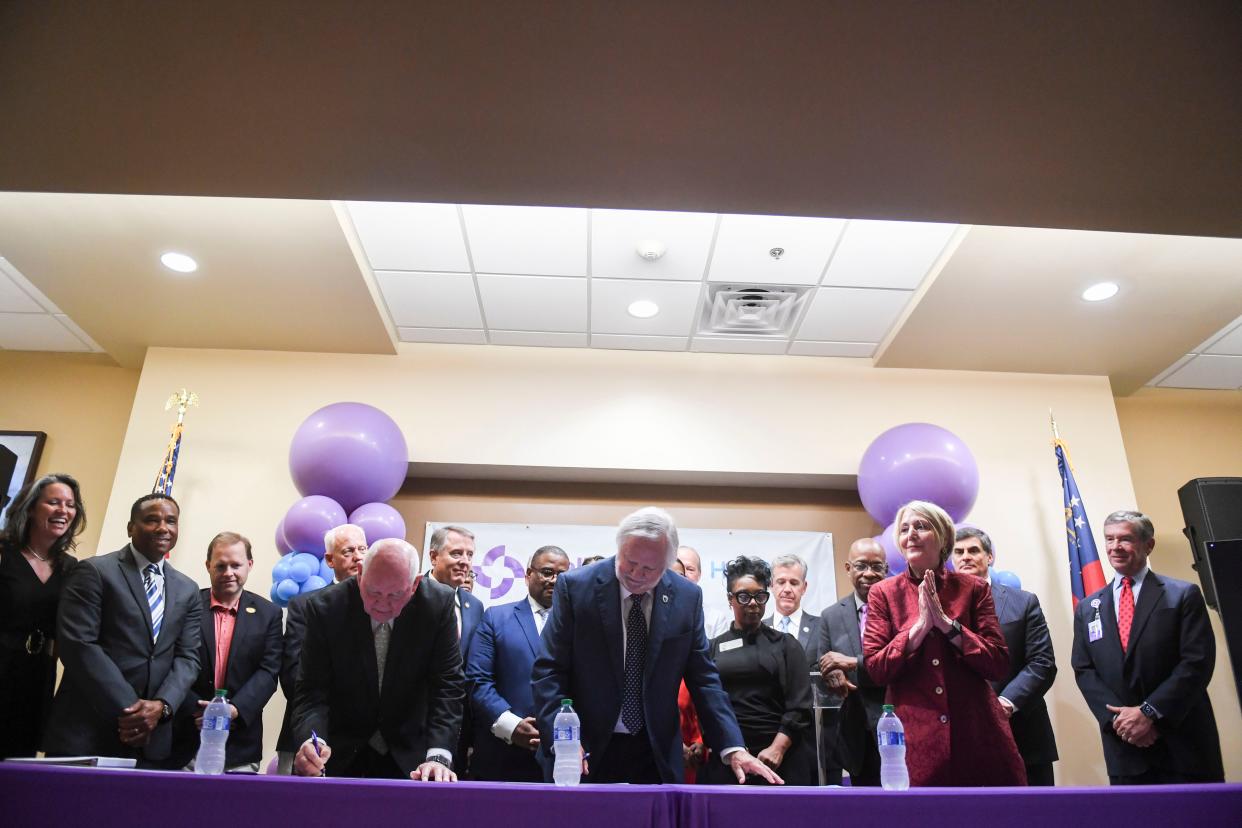 [From left] Chancellor Sonny Perdue, Augusta University President Brooks Keel, and Wellstar President and CEO Candice Saunders sign documents during the Wellstar and Augusta University Health System merger signing ceremony at Augusta University on Wednesday, Aug. 30, 2023.