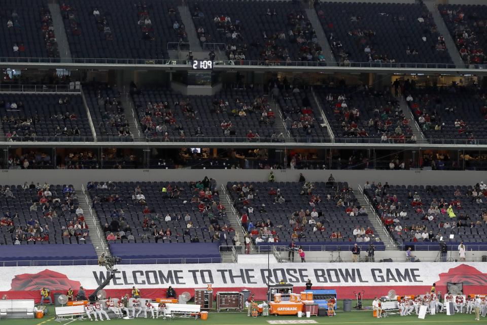 A banner along the sideline at AT&T Stadium reads, "Welcome To The Rose Bowl Game", as fans watch the teams warm up before the Rose Bowl NCAA college football game between Notre Dame and Alabama in Arlington, Texas, Friday, Jan. 1, 2021. (AP Photo/Roger Steinman)