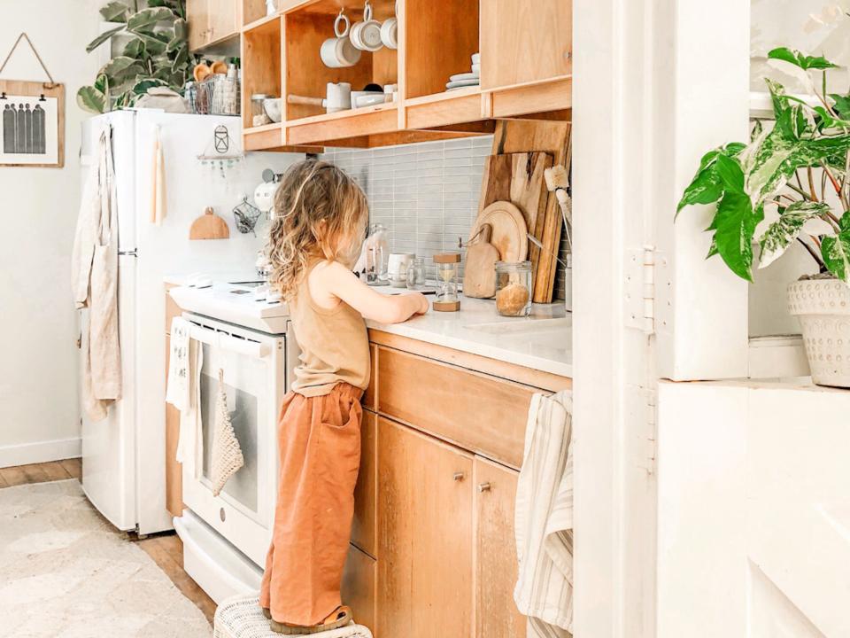 a little girl standing at the counter in the kitchen at The Tiny Canal Cottage by Whitney Leigh Morris