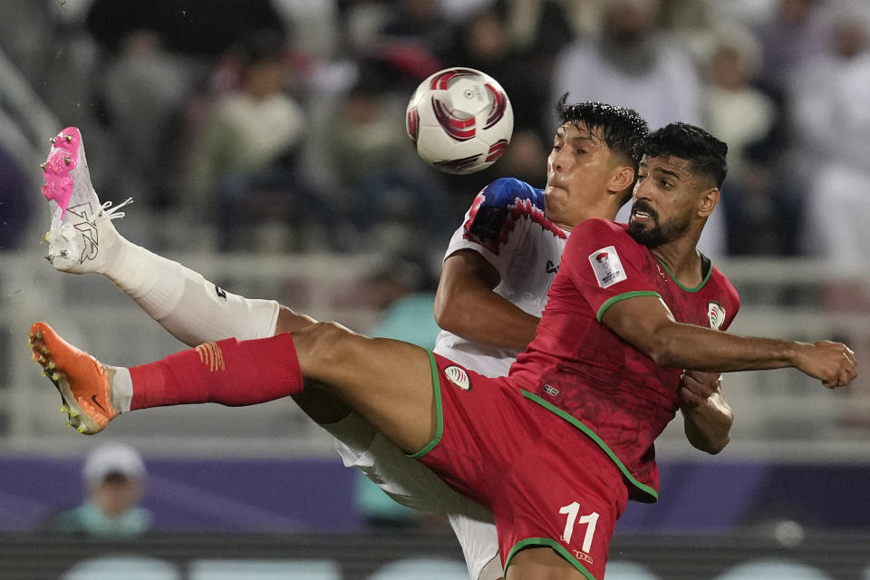 Muhsen Saleh Al Ghassani, de Omán, al frente, y Elias Dolah, de Tailandia, luchan por el balón durante el partido de fútbol del Grupo F de la Copa Asiática entre Tailandia y Omán en el estadio Abdullah Bin Khalifa en Doha, Qatar, el domingo 21 de enero de 2024. (AP Foto/Thanassis Stavrakis)