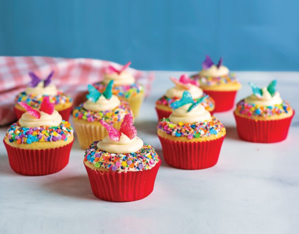 Cupcakes with rainbow sprinkles and butterfly garnish
