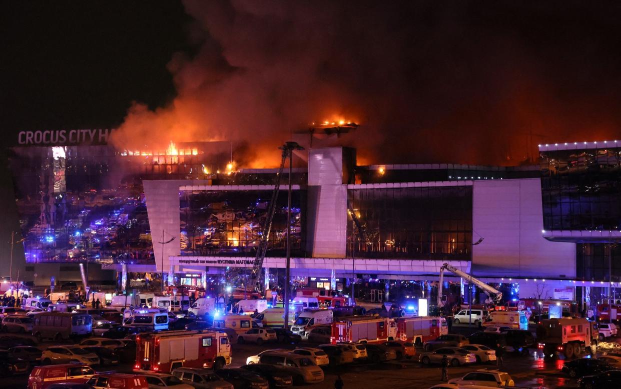 Emergency services vehicles outside the burning Crocus City Hall concert hall following the shooting in Krasnogorsk, outside Moscow, on Friday