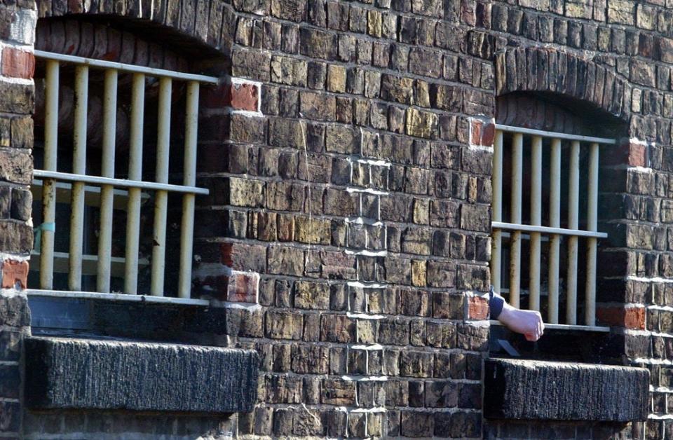 A prisoners hand pokes through bars (Andrew Parsons/PA) (PA Archive)