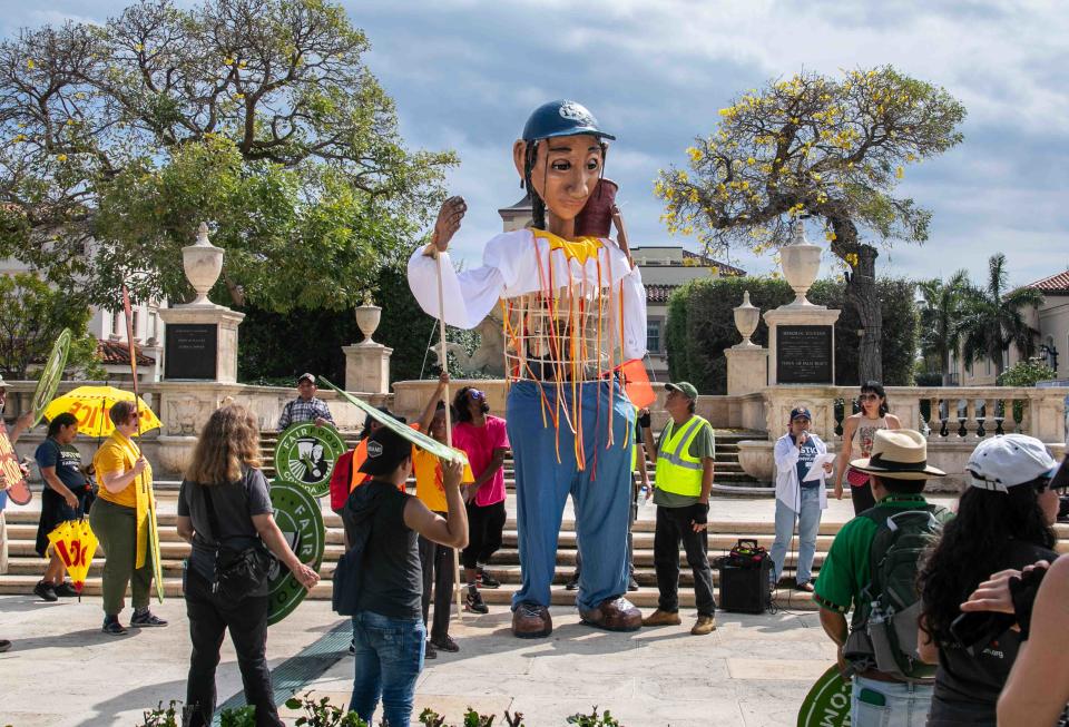 A 16-foot puppet named Esperanza stands behinds Palm Beach Town Hall Friday during the start of a three-day Farmworker Freedom Festival.