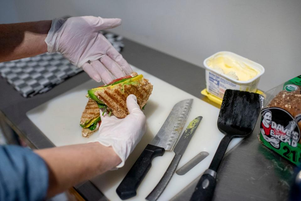 Entrepreneur Trish Case prepares a grilled cheese spinach and tomato panini at her vegan eatery VeggZ Cafe on Tuesday, Dec. 15, 2020 in Battle Creek, Mich. 