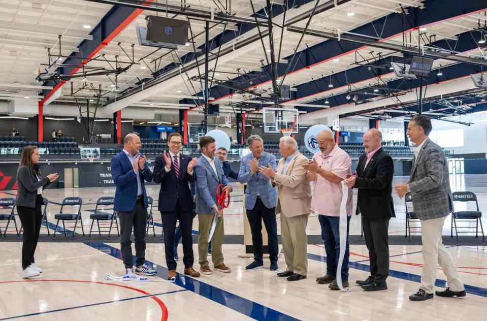 Dignitaries including Kansas Lt. Gov. David Toland, third from left, Trey Bowen with scissors, Dustin Lewis, Homefield KC president, fifth from left, Greg Maday, sixth from right, and others react after cutting the ribbon at Homefield Kansas City.