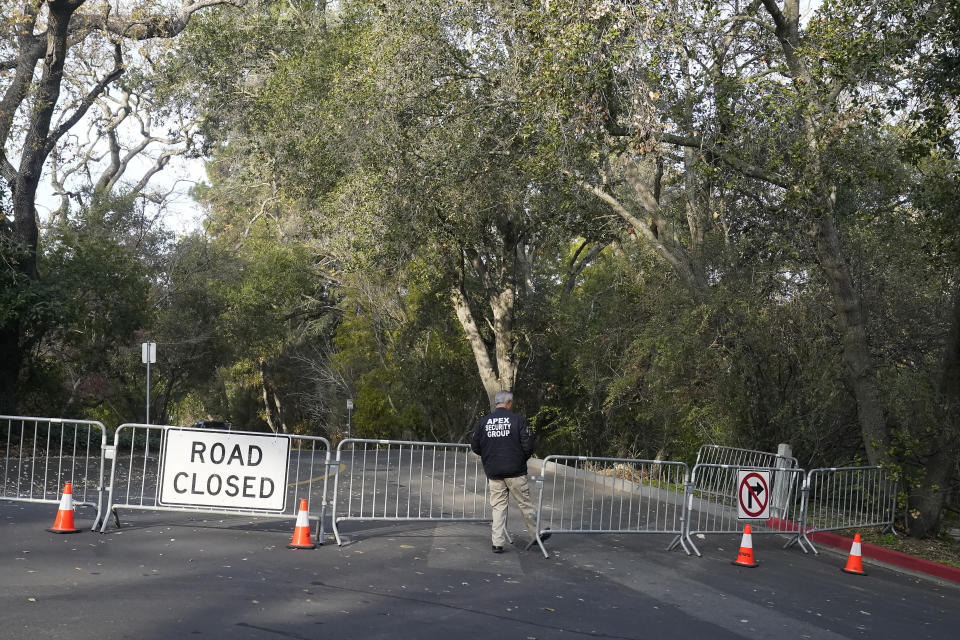 A guard closes barricades to a street near the family home of FTX founder Sam Bankman-Fried in Palo Alto, Calif., Friday, Dec. 23, 2022. Bankman-Fried's parents agreed to sign a $250 million bond and keep him at their California home while he awaits trial on charges that he swindled investors and looted customer deposits on his FTX trading platform. (AP Photo/Jeff Chiu)