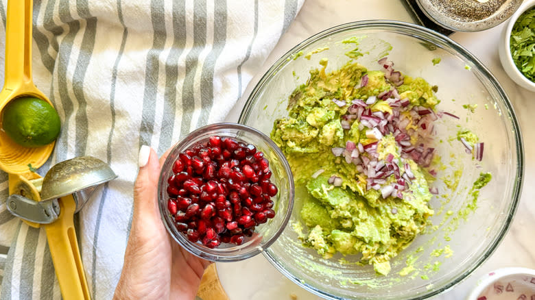 adding pomegranate seeds to bowl