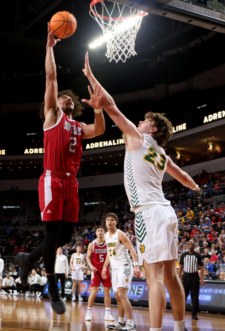 Damani Hayes #2 of the South Dakota Coyotes leaps for a basket against Andrew Morgan #23 of the North Dakota State Bison at the 2023 Summit League Basketball Championship at the Denny Sanford Premier Center in Sioux Falls, South Dakota. (Photo by Dave Eggen/Inertia)