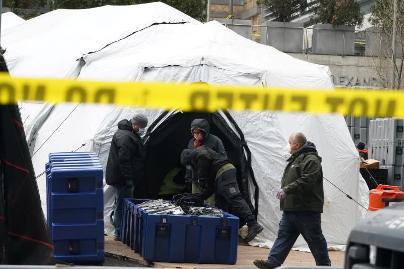 Varios agentes sanitarios construyen lo que se cree que es una morgue improvisada detrás de un hospital durante el brote de coronavirus en Manhattan