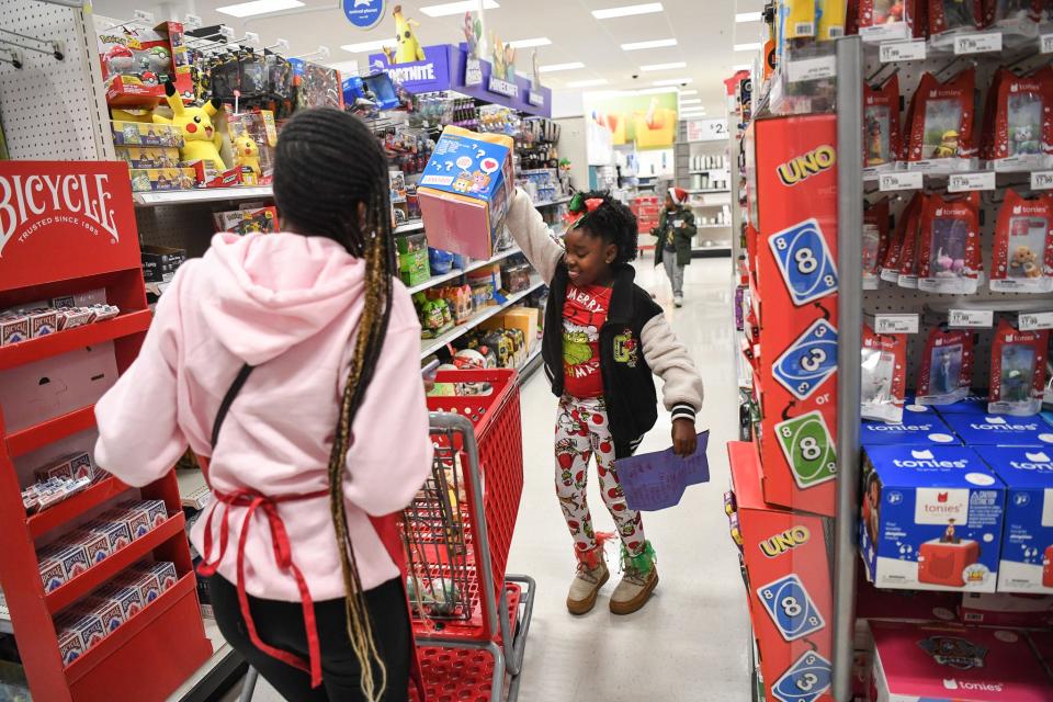 Tori Oliver picks out a toy for herself at the Weigel's Family Christmas.