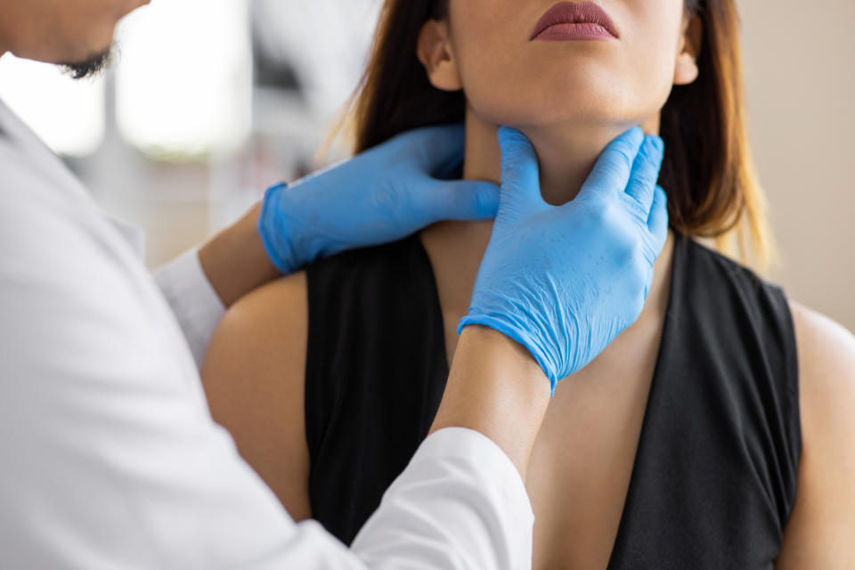 Doctor palpating a patient's neck for a medical examination