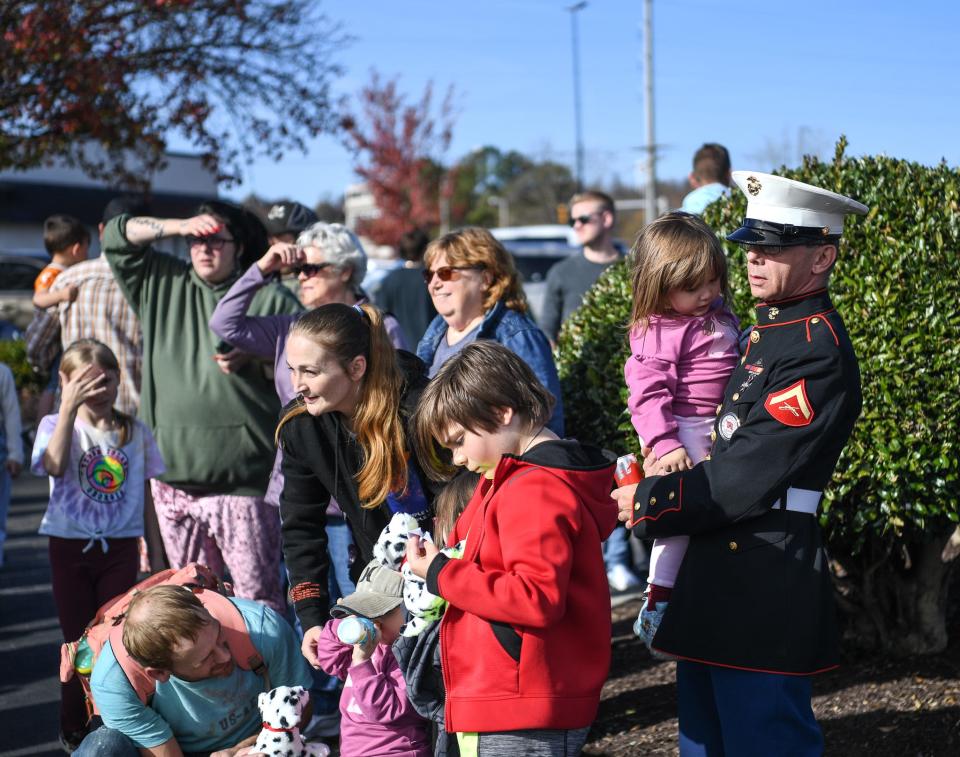 Lance Corporal Skipper Bass of the Veteran State Honor Guard watches the world-famous Budweiser Clydesdale horses with granddaughter Avi and his family at Food City in Oak Ridge, Saturday, Nov. 11, 2023.