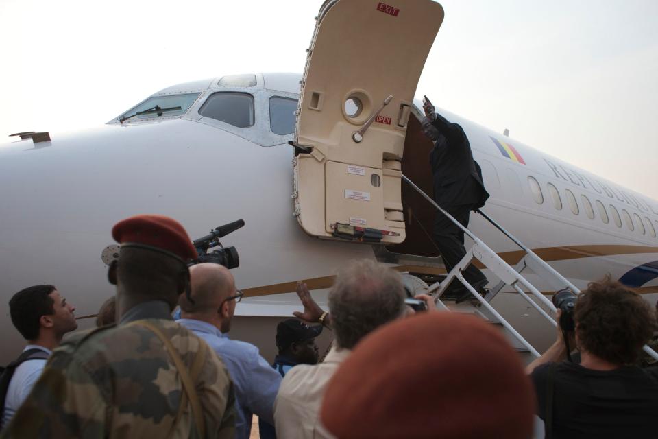 Central African Republic President Michel Djotodia gives a cursory wave as he boards a plane to Chad, at Mpoko Airport in Bangui, Central African Republic, Wednesday, Jan. 8, 2014. The embattled president, who has come under growing pressure to resign, traveled to neighboring Chad on Wednesday for a summit with regional leaders who want to end the bloodshed that has left more than 1,000 dead and nearly a million people displaced.(AP Photo/Rebecca Blackwell)