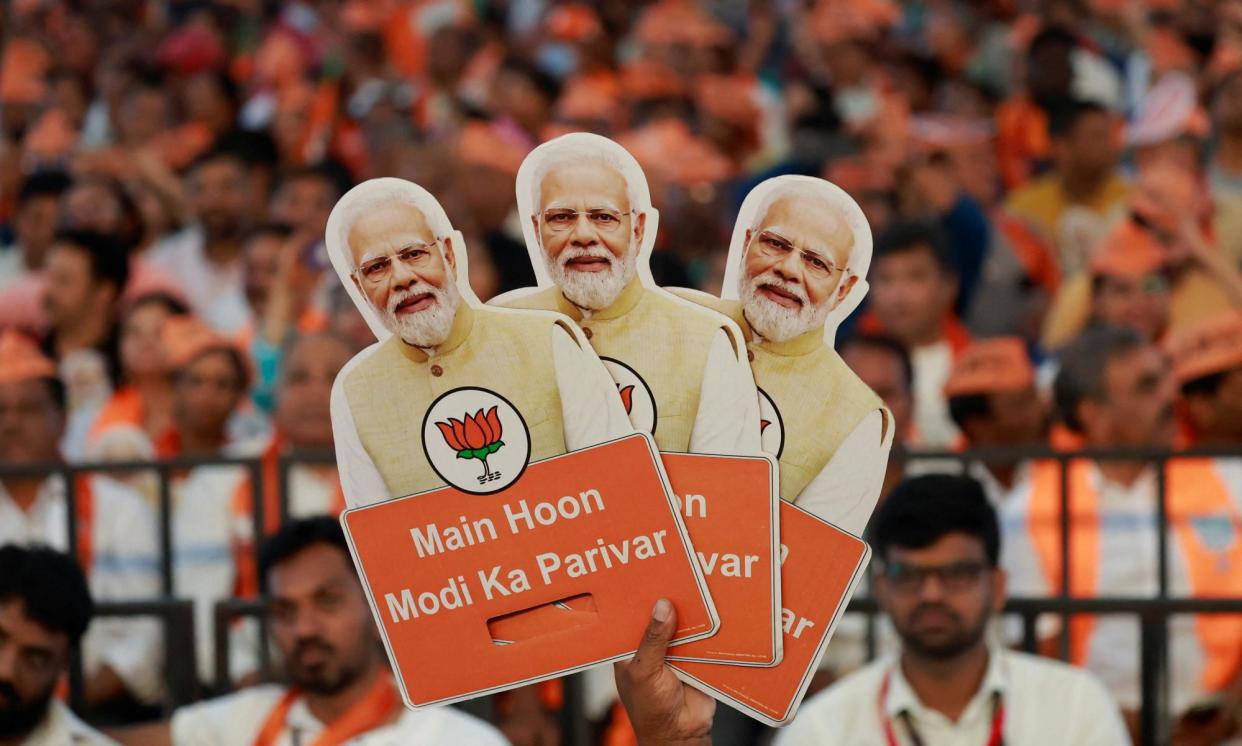 <span>A BJP supporter holds cutouts of Narendra Modi during an election rally at the weekend in Bengaluru, India.</span><span>Photograph: Navesh Chitrakar/Reuters</span>