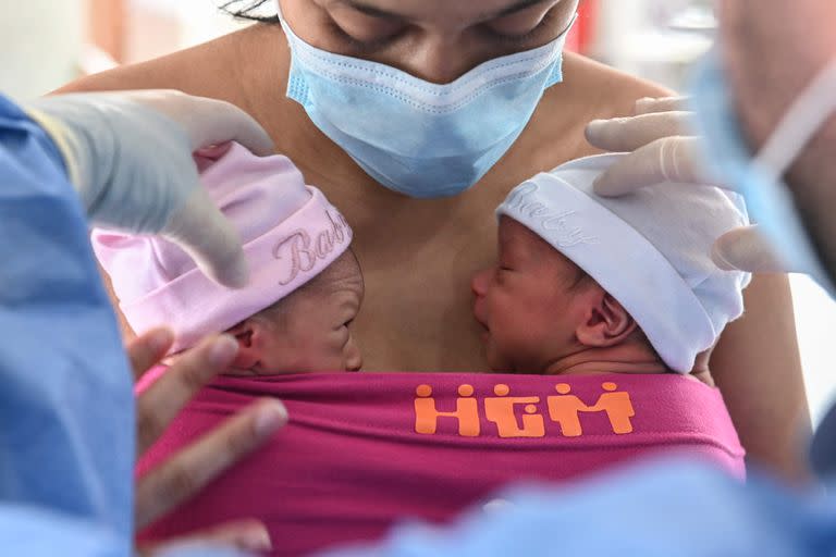 En esta foto de archivo del 21 de mayo de 2020 una madre amamanta a sus gemelos recién nacidos mientras un médico la ayuda, durante la pandemia del coronavirus
, en la sala de lactancia postnatal del Hospital General de Medellín, en Medellín.