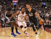 Dec 5, 2015; Toronto, Ontario, CAN; Golden State Warriors guard Stephen Curry (30) dribbles past Toronto Raptors guard Kyle Lowry (7) and Warriors center Festus Ezeli (31) in the second quarter at Air Canada Centre. Mandatory Credit: Dan Hamilton-USA TODAY Sports