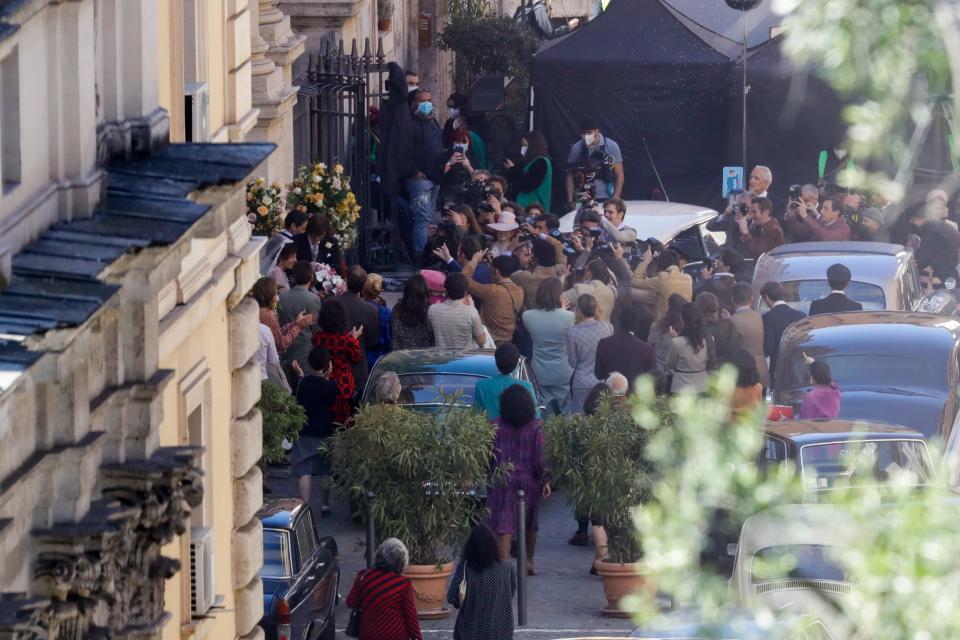 Lady Gaga, wearing a wedding dress in background left, plays Maurizio Gucci's former wife Patrizia Reggiani during the shooting of a movie by Ridley Scott, based on the story of the murder of Maurizio Gucci in 1995, in Rome, Thursday, April 8, 2021. (AP Photo/Andrew Medichini)