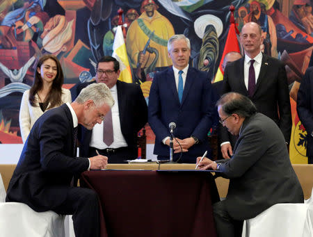 Wolfgang Schmutz (L) from Germany firm ACI Systems GmbH and Juan Carlos Montegro of state-owned Bolivian Lithium Deposits (YLB) sign an agreement at the presidential palace La Casa Grande del Pueblo in La Paz, Bolivia, October 5, 2018. REUTERS/David Mercado