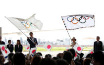 Tokyo governor Yuriko Koike (R) and Japan's Olympic team's sub-captain Keisuke Ushiro wave the Olympic flag (R) and JOC flag during a ceremony to mark the arrival of the Olympic flag at Haneda airport in Tokyo, Japan, August 24, 2016. REUTERS/Kim Kyung-Hoon