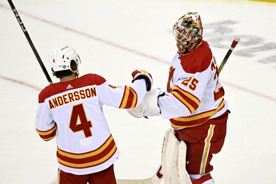 Calgary Flames goaltender Jacob Markstrom (25) celebrates with defenseman Rasmus Andersson (4) after the Flames defeated the New Jersey Devils in an NHL hockey game Thursday, Feb. 8, 2024, in Newark, N.J. (AP Photo/Bill Kostroun)