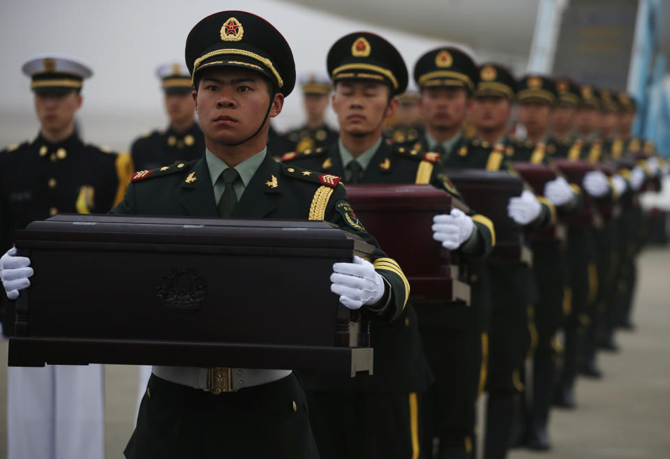 Chinese honor guards hold caskets containing the remains of Chinese soldiers during the handing over ceremony of the remains at the Incheon International Airport in Incheon, South Korea Friday, March 28, 2014. The remains of more than 400 Chinese soldiers killed during the 1950-53 Korean War were transferred from the temporary columbarium in South Korea to the airport to return home for permanent burial. (AP Photo/Kim Hong-ji, Pool)