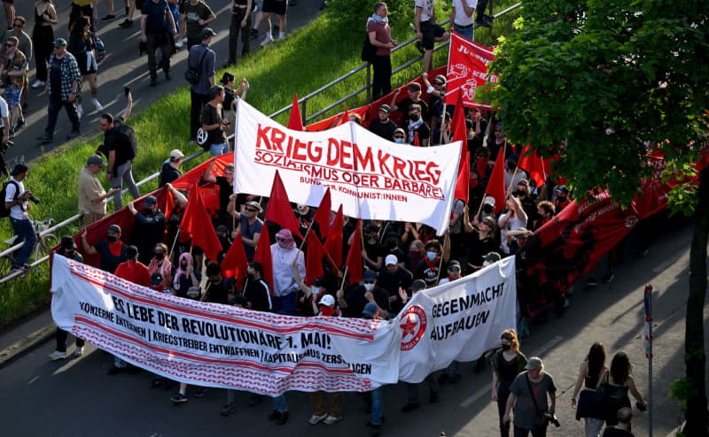 People hold up a banner with the words "War against war" during the "Revolutionary May Day demonstration".  Sebastian Gollnow/dpa
