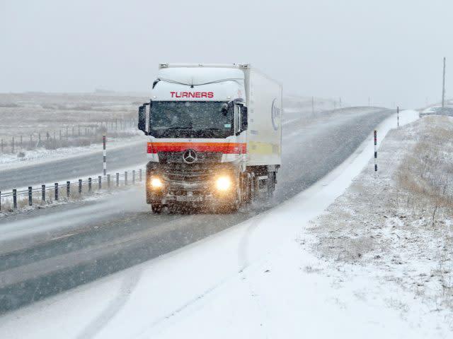 A lorry makes its way through the snow on the A66 in Cumbria (Owen Humphreys/PA)