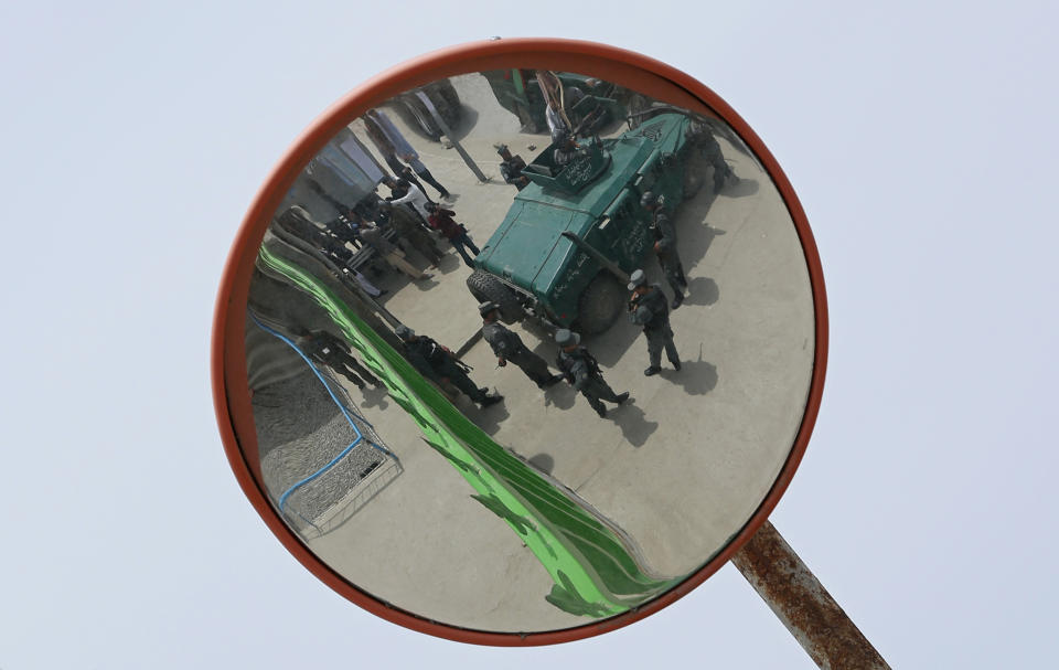 Afghan police forces are reflected in a security mirror, in front of the main gate of Cure International Hospital in Kabul, Afghanistan, Thursday, April 24, 2014. (AP Photo/Massoud Hossaini)