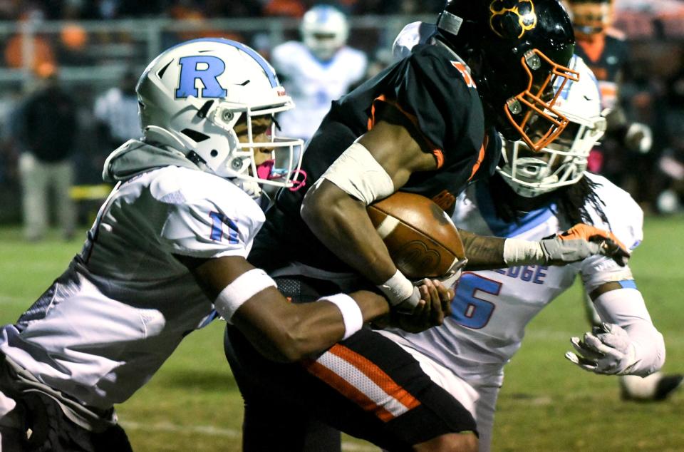 Cocoa’s Jmariyae Robinson is brought down by Derrick McCormick and Phineas Allen of Rockledge during their game Nov. 6, 2021. Craig Bailey/FLORIDA TODAY via USA TODAY NETWORK