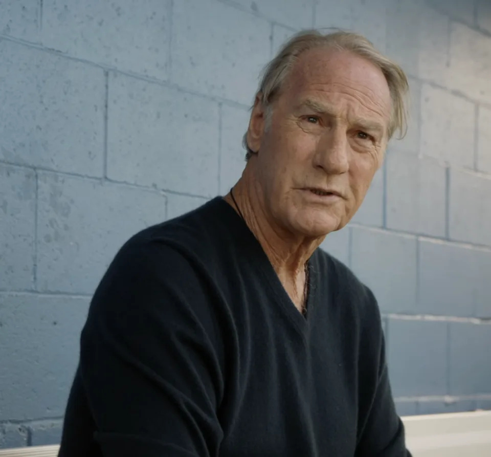 Dale in a t-shirt sitting in a dugout