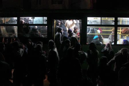 Rebel fighters and civilians who left the Homs district of Waer under a local truce, arrive in buses at Idlib city, Syria December 10, 2015. REUTERS/Ammar Abdullah