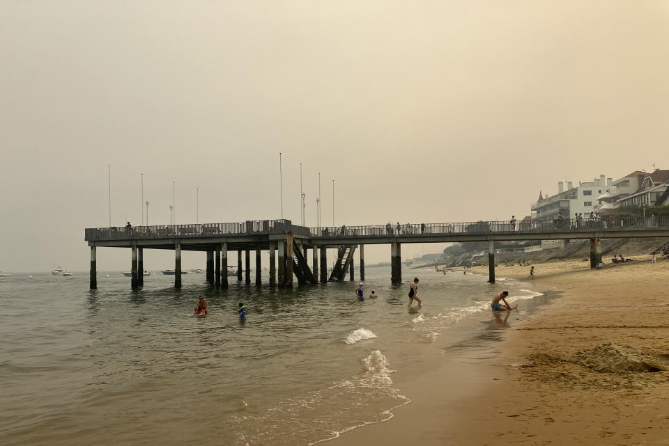 FILE - Smoke from a wildfire colors the sky in Arcachon, southwestern France, despite being approximately 45 kilometers away Thursday, Aug. 11, 2022. Europe's sky-high natural gas prices have fallen thanks to unseasonably warm weather and efforts to fill up storage ahead of winter. Prices have fallen to their lowest level since June and electricity is cheaper, too. Lower use by industry has helped to reduce demand for fuel as well. (AP Photo/Bertrand Combaldieu, file)