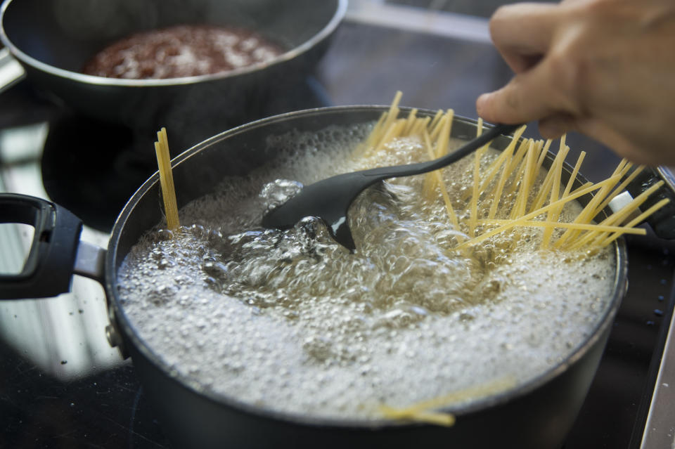 boiling spaghetti in a large pot of stock