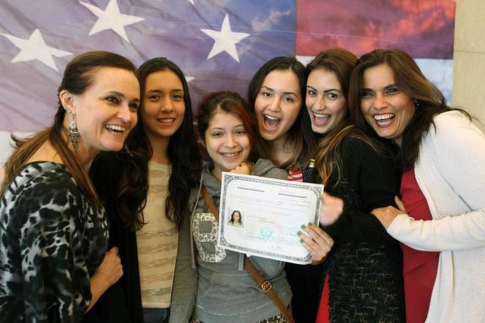 Mariana Sarname de Perú, (tercera de la derecha), acompañada de familiares, muestra su alegría mostrando su certificado de Naturalización durante una ceremonia celebrada en las oficinas de Kendall USCIS.