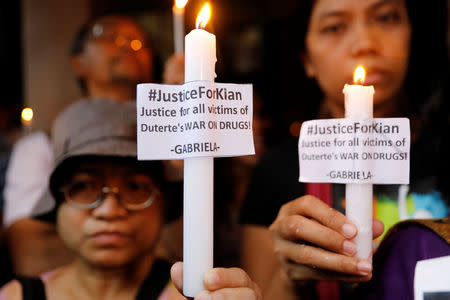 Residents and protesters hold lighted candles at the wake of Kian Loyd delos Santos, a 17-year-old high school student, who was among the people shot dead last week in an escalation of President Rodrigo Duterte's war on drugs in Caloocan city, Metro Manila, Philippines August 21, 2017. REUTERS/Erik De Castro