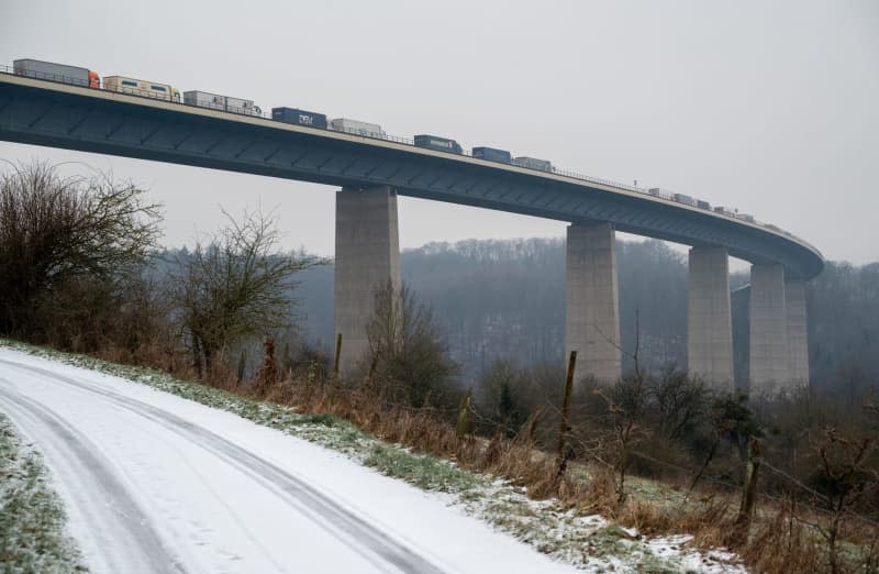 Trucks queue on the A64 before the border to Luxembourg. Snow and black ice have caused considerable traffic delays in Rhineland-Palatinate. Harald Tittel/dpa