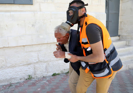 A medic evacuates a Palestinian man after inhaling tear gas fired by Israeli troops during clashes following a protest in solidarity with Palestinian prisoners held by Israel, in the West Bank town of Bethlehem April 17, 2017. REUTERS/Ammar Awad