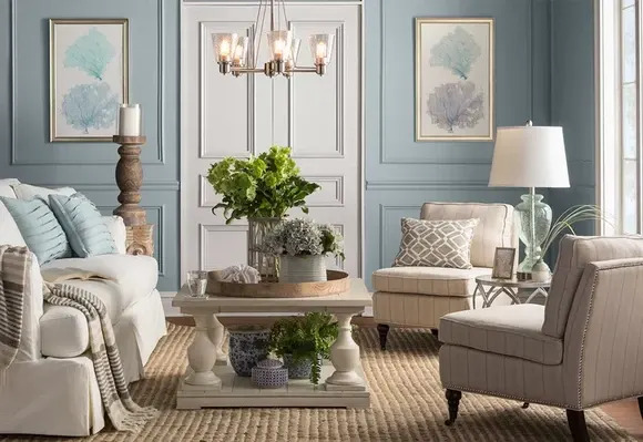 A tan living room set with aqua pillows from Wayfair brand Joss & Main, in a light blue room.