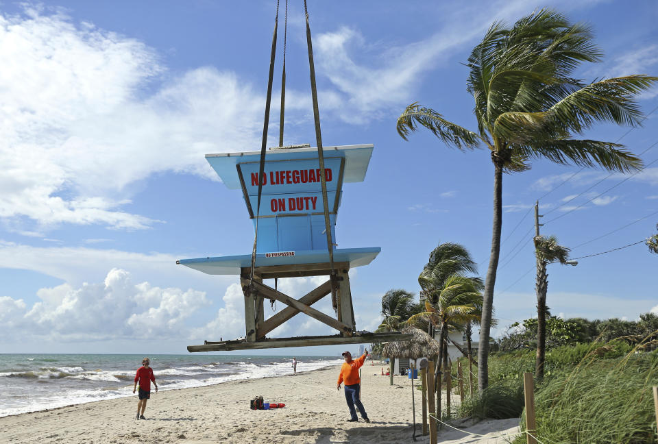 Gold Coast Crane workers and Dania Beach lifeguards remove the lifeguard tower in preparation for Hurricane Dorian as the storm approaches the Florida coast on Saturday, Aug. 31, 2019 at Dania Beach, Fla. The latest forecast says Hurricane Dorian is expected to stay just off shore of Florida and skirt the coast of Georgia, with the possibility of landfall still a threat on Wednesday, and then continuing up to South Carolina early Thursday. (David Santiago/Miami Herald via AP)