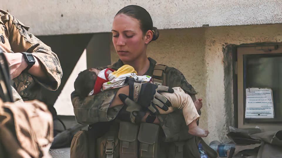 In this August 20, 2021, image provided by the US Marine Corps, Sgt. Nicole Gee is seen calming an infant during an evacuation at Kabul airport in Afghanistan. Officials said on August 28, 2021, that Gee was among the Marines killed in a bombing at the airport. - Sgt. Isaiah Campbell/US Marine Corps/AP
